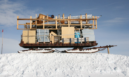 A portrait of the drillers sled resting on its snow hill.